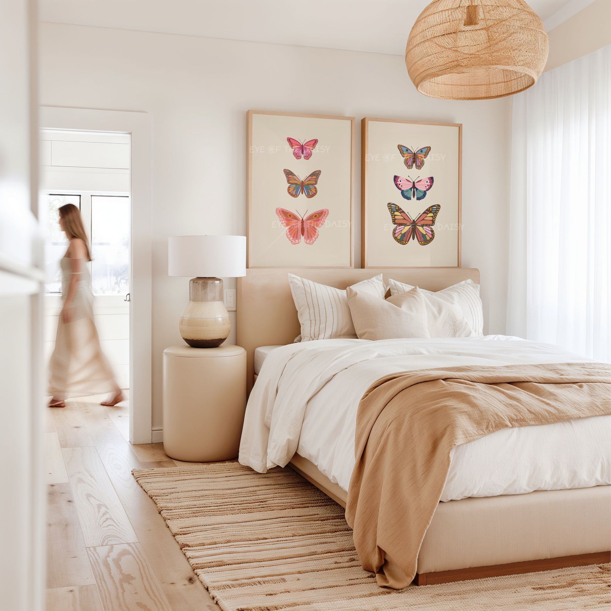 Set of 2 modern vintage butterfly printable art prints in beige, pink and brown, displayed above a bed in a boho bedroom