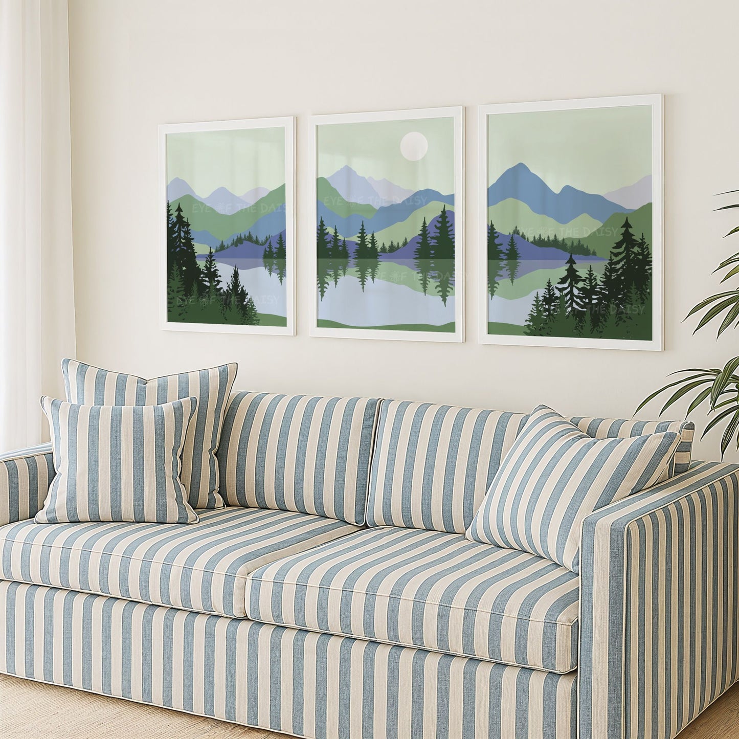 Set of 3 sage green navy blue abstract mountain digital art prints, showing a mid century modern landscape scene with trees and a lake, in a living room