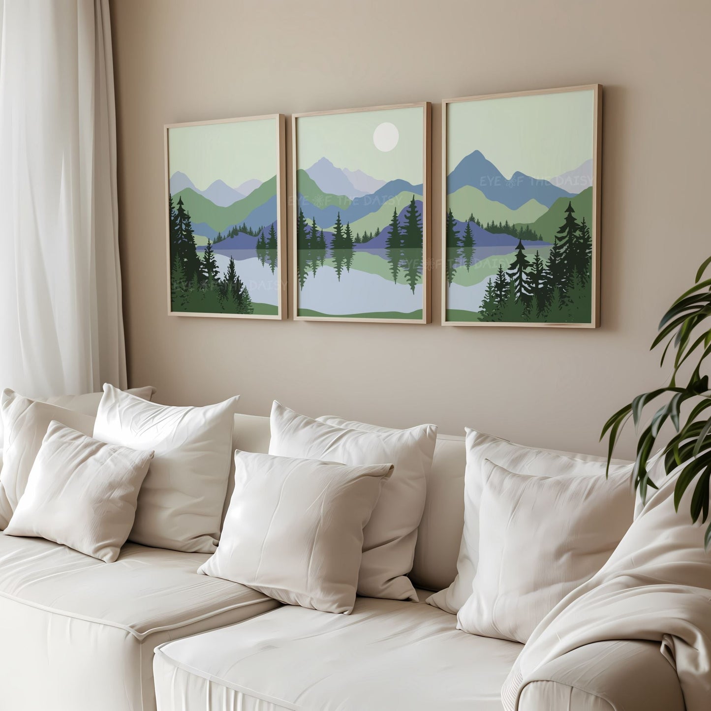 Triptych set of 3 sage green & blue minimalist landscape art prints of a mountain scene with trees and a lake, in a beige living room