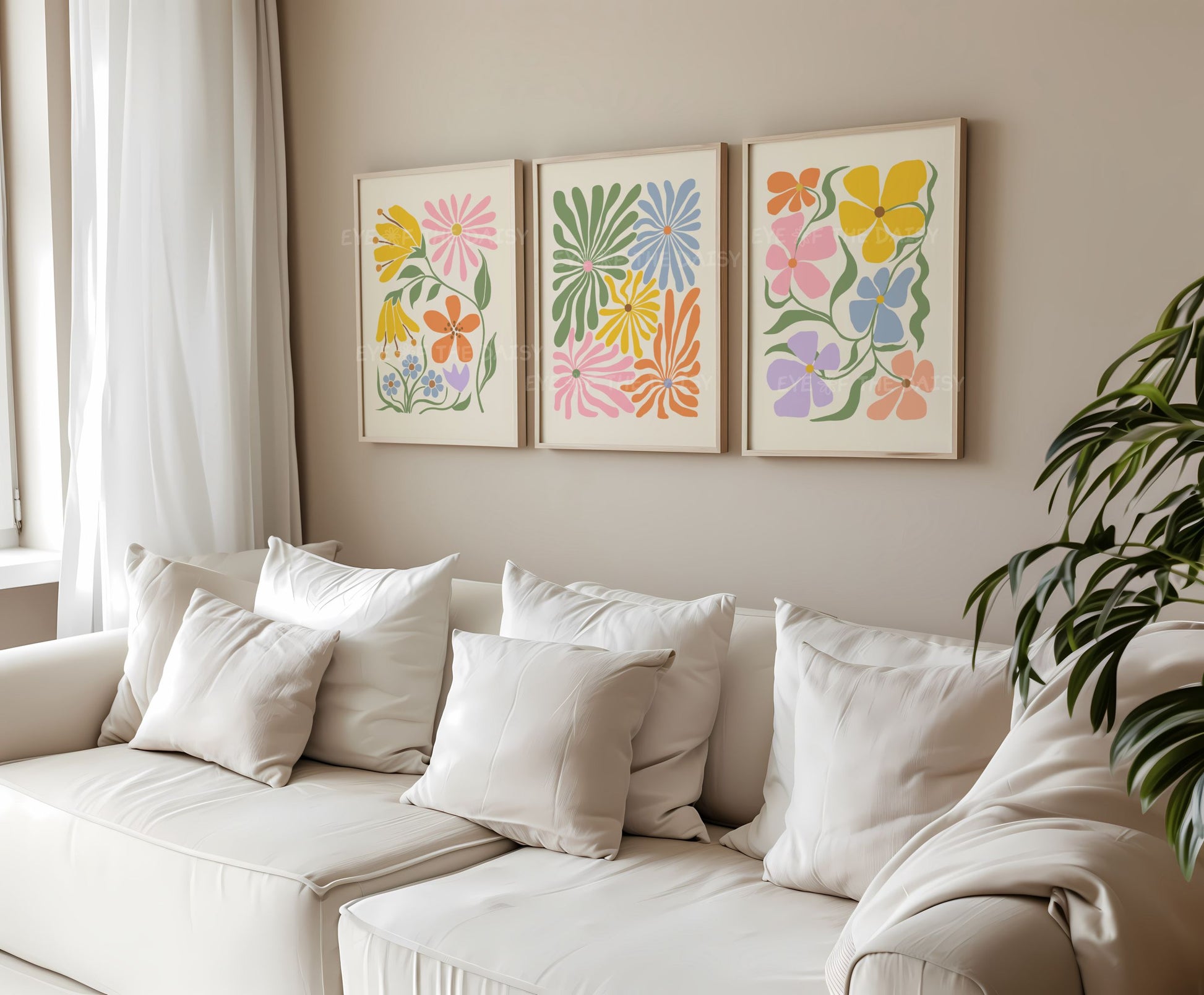 A set of three vibrant botanical abstract digital prints in a living room with colorful retro abstract flower cut-outs in pastel pink, mustard, green, lilac, blue on beige