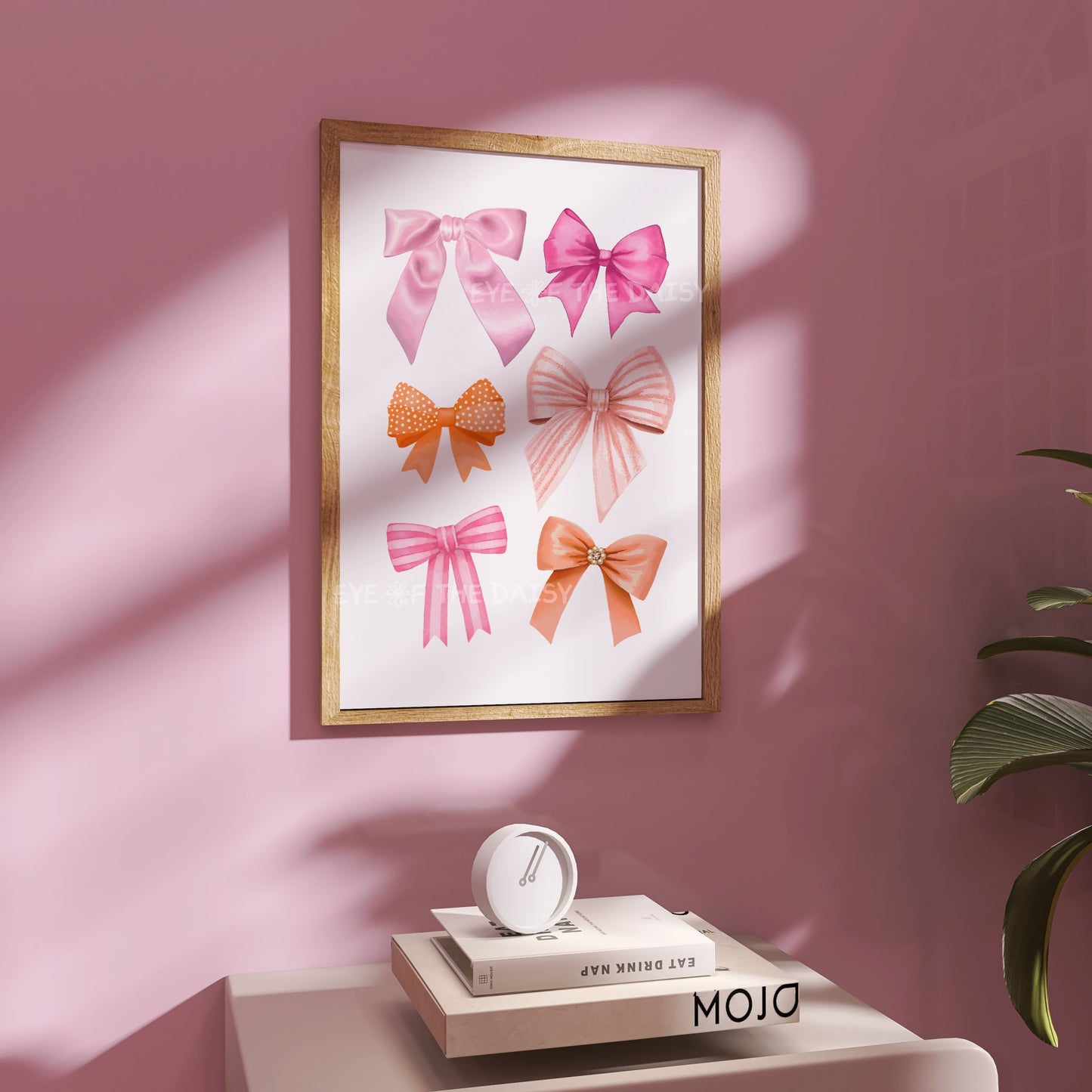 Trendy printable wall art of pink & orange ribbons & bows, displayed on a pastel pink wall