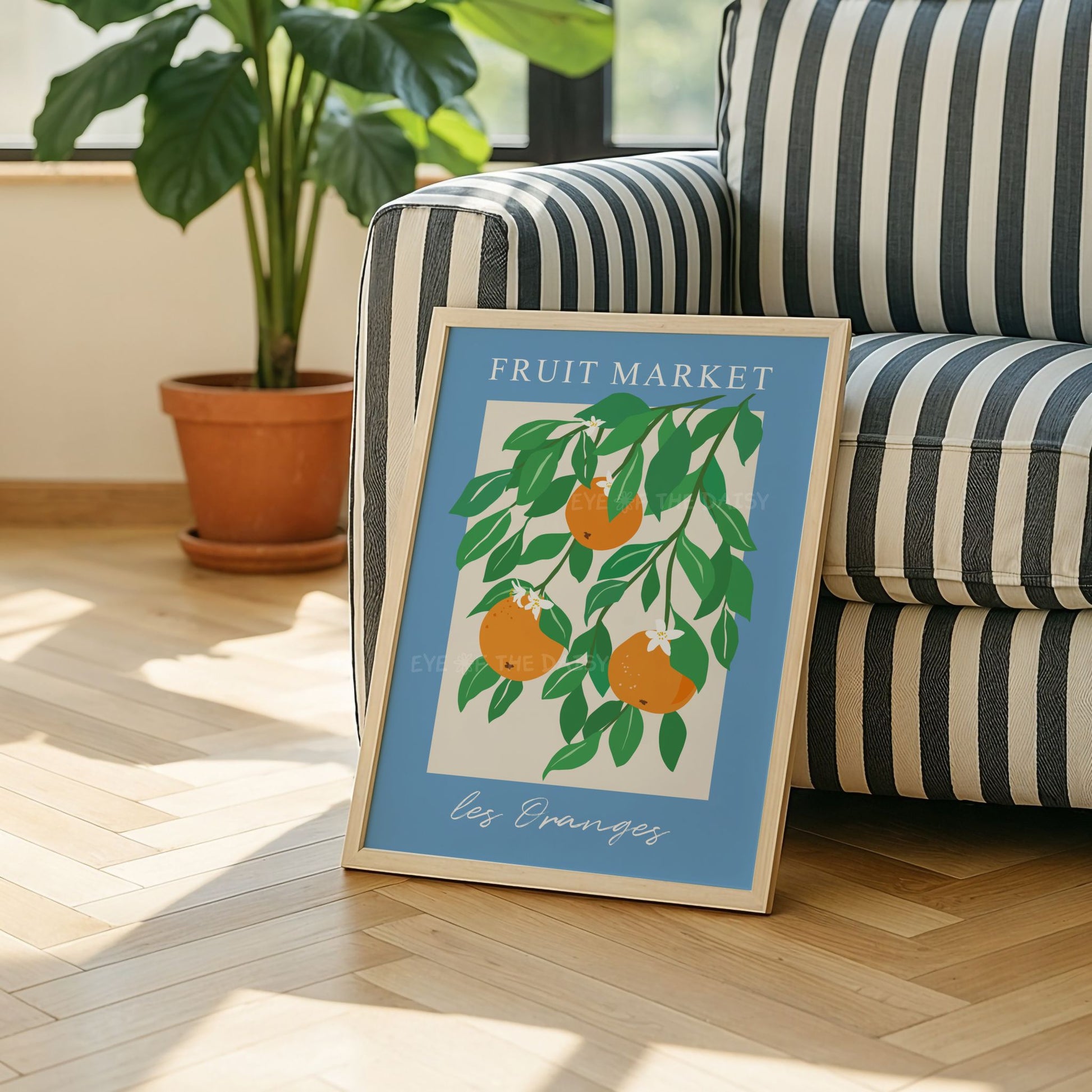 Contemporary botanical wall decor of orange tree – vibrant Les Oranges Fruit Market art print with blue border styled in a boho living room