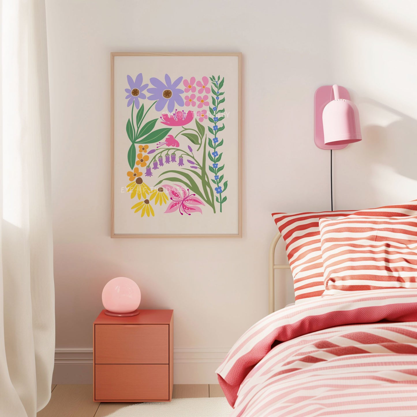 Colourful botanical art print with vibrant lilac, purple, blue, green, orange, yellow and pink abstract flowers and leaves intertwining on a light beige background framed against a wall in a bedroom near pink and red striped bedding with a pink lamp