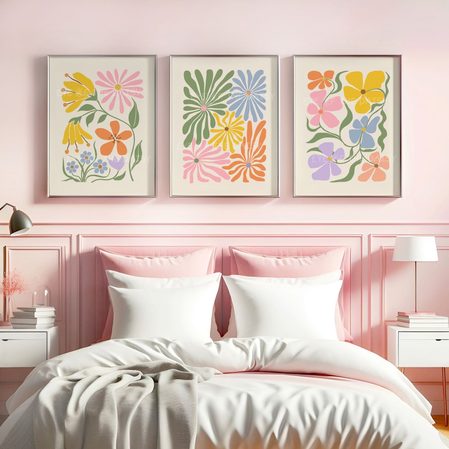 A set of three vibrant botanical abstract digital prints with colorful retro abstract flower cut-outs in pastel pink, mustard yellow, green, lilac, peach, blue above a bed in a pink bedroom