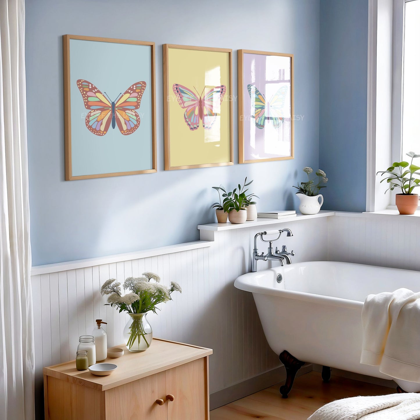 Set of three pastel colourful butterfly art prints displayed on the wall of a modern sophisticated bathroom